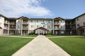 Red Deer apartment for rent - A large apartment complex with a walkway in front.