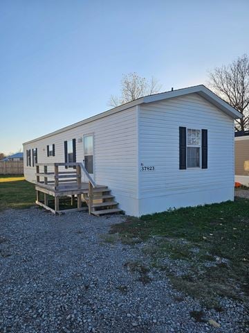 Shawnee house for rent - A small white house with a porch and a garage door.