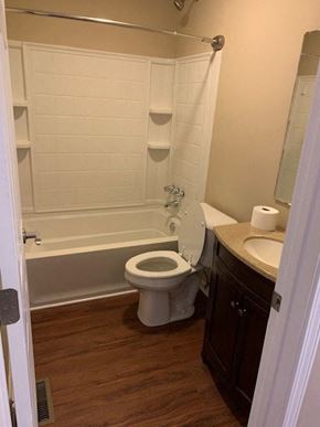Hope Mills house for rent - A white toilet in a bathroom with a wooden floor.