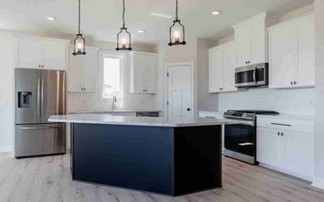 Blaine house for rent - a large kitchen with white cabinets and stainless steel appliances