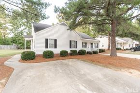 Clayton apartment for rent - A white house with a black roof and a driveway in front.