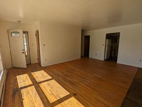 Great Falls apartment for rent - an empty living room with wooden floors and white walls
