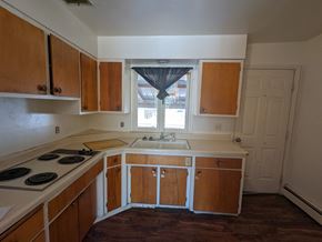 Great Falls apartment for rent - an empty kitchen with wooden cabinets and a window
