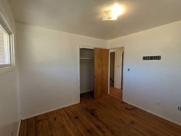 Great Falls apartment for rent - a bedroom with white walls and wooden floors and a door to a closet