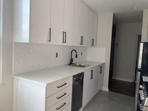 Toronto apartment for rent - a white kitchen with white cabinets and a sink