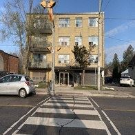 Toronto apartment for rent - a car driving down a street in front of a building