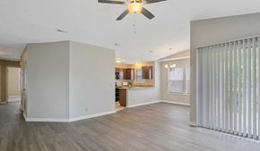 Fayetteville house for rent - an empty living room and kitchen with a ceiling fan