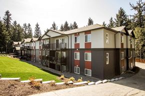 Nanaimo apartment for rent - A row of townhouses with a green lawn in front.