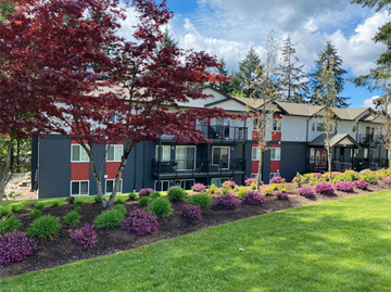Nanaimo apartment for rent - A building with a red tree in front of it.