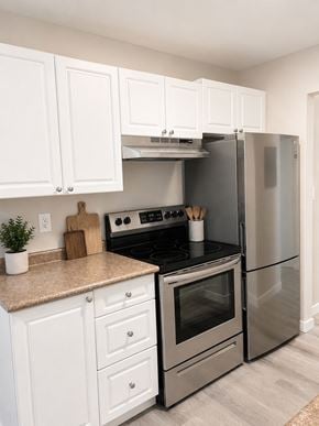 Nanaimo apartment for rent - A kitchen with a stove top oven and a refrigerator.