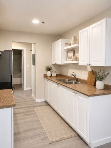 Nanaimo apartment for rent - A kitchen with white cabinets and a brown countertop.