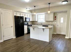 Columbia apartment for rent - a kitchen with white cabinets and a black refrigerator