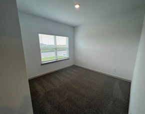 Rosharon house for rent - A room with a carpeted floor and a window with blinds.