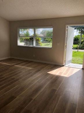Port St. Lucie house for rent - A room with wooden flooring and a window with blinds.