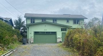 Sitka apartment for rent - a green house with a green garage door