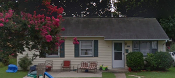 Hampton house for rent - a house with a yard and a rocking chair in front of it