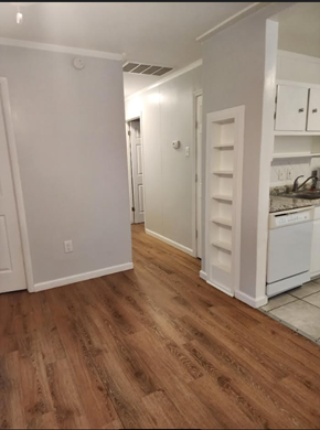Hampton house for rent - a kitchen with a wooden floor and white cabinets