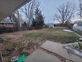 Wheat Ridge house for rent - the backyard of a house with a yard and a fence