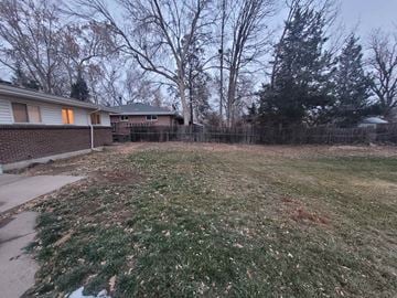Wheat Ridge house for rent - the backyard of a house with a yard and a fence