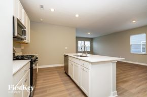 Danville house for rent - A kitchen with white cabinets and a black stove top oven.