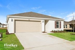 Davenport house for rent - a beige house with a garage door and a driveway