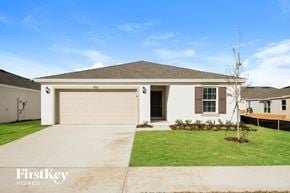 Davenport house for rent - a beige house with a garage door and a lawn