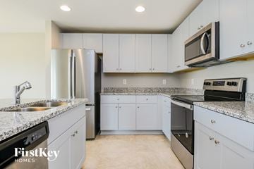 Davenport house for rent - a kitchen with white cabinets and granite counter tops and stainless steel appliances