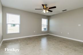 Davenport house for rent - A spacious room with a ceiling fan and two windows.