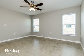 Davenport house for rent - A spacious room with a ceiling fan and two windows.