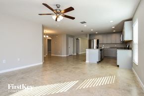 Davenport house for rent - an empty kitchen and living room with a ceiling fan