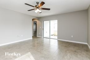 Davenport house for rent - an empty living room with a ceiling fan and a door to a hallway