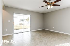 Davenport house for rent - an empty living room with a ceiling fan and sliding glass doors