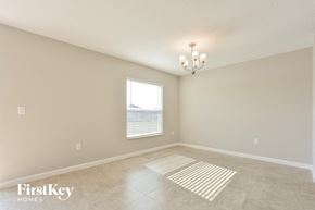 Davenport house for rent - A room with a chandelier, a window with blinds, and a rug on the floor.