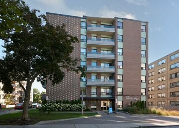 Toronto apartment for rent - A tall apartment building with a brick facade and balconies.