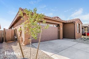 Litchfield Park house for rent - a home with a garage door and a tree in front of it