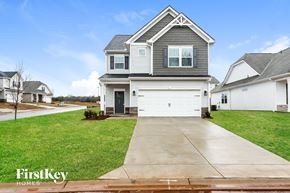 Greenville house for rent - A house with a grey roof and a white garage door is for sale.