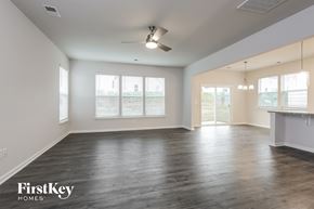 Greenville house for rent - A spacious room with wooden floors and a ceiling fan.
