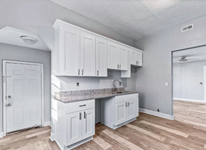 Portsmouth apartment for rent - A kitchen with white cabinets and a granite countertop.