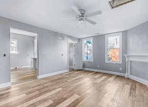 Portsmouth apartment for rent - A room with a ceiling fan and wooden flooring.