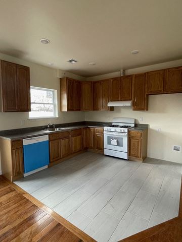 Newark apartment for rent - an empty kitchen with wooden cabinets and a stove