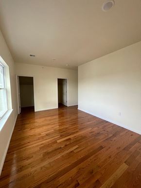 Newark apartment for rent - an empty living room with wood flooring and white walls