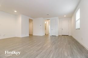 Glendale house for rent - A spacious empty room with wooden flooring and white walls.