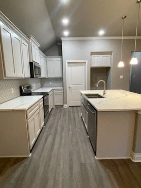 Greenville house for rent - A kitchen with white cabinets and a grey floor.