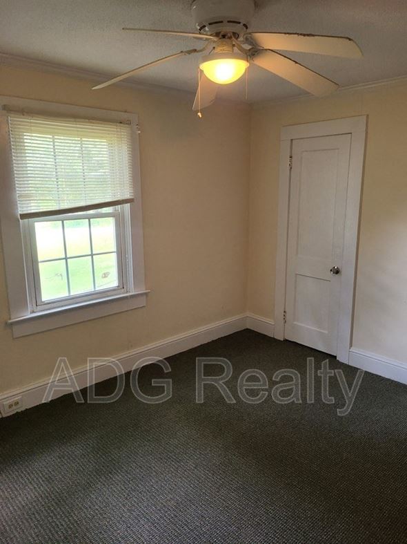 Gastonia house for rent - a small bedroom with a ceiling fan and a window