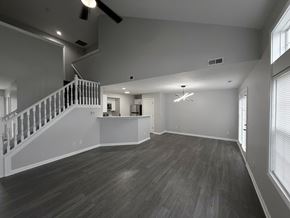 Indianapolis townhouse for rent - A spacious room with a staircase and a ceiling fan.