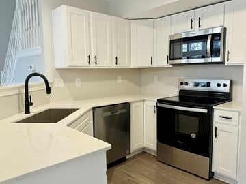 Indianapolis townhouse for rent - A kitchen with white cabinets and a black oven.