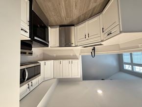 Indianapolis townhouse for rent - A kitchen with white cabinets and black appliances.