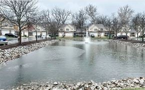 Indianapolis townhouse for rent - A pond in a residential area with houses and bare trees.