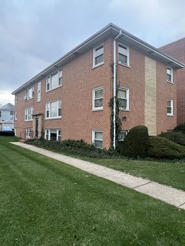 Chicago apartment for rent - A red brick building with a white trim and a green lawn in front.