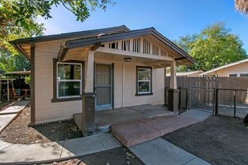 Escondido apartment for rent - a small tan house with a porch and a black fence